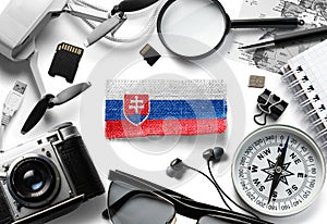 Slovenská vlajka a cestovní doplňky na bílém pozadí.
