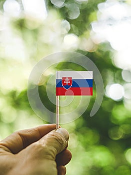 Vlajka Slovenska, ktorá sa drží v ruke.