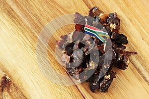 Flag of South Africa on traditional biltong snack on a wooden surface