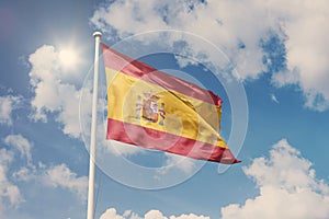 Flag of Spain, National symbol waving against cloudy, blue sky, sunny day