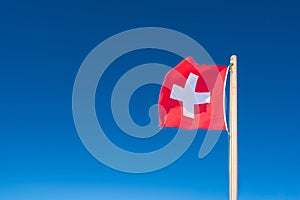Flag of Switzerland against the background of the blue sky. Top of Jungfrau