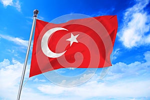 Flag of Turkey developing against a blue sky