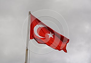 Flag of Turkey rise waving to the wind with sky in the background photo