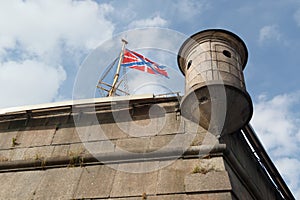 Flag and turret on Naryshkin bastion of Peter and Paul Fortress on a background cloudy sky in St-Petersburg