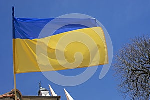 Flag of ukraine in the blue sky over the city liberated from the occupier, the war in ukraine
