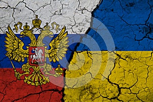 Flag of Ukraine and Russia on textured cracked earth. The concept of cooperation between the two countries