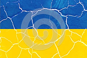 Flag of Ukraine on the texture of cracked earth. Russian-Ukrainian military conflict