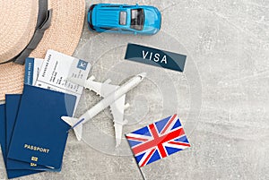 Flag of United Kingdom with passport and toy airplane on wooden background. Flight travel concept