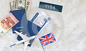 Flag of United Kingdom with passport and toy airplane on wooden background. Flight travel concept