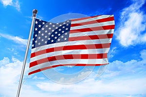 Flag of United States of America USA developing against a blue sky