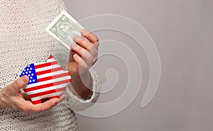 Flag of USA on money bank in American woman hands. Dotations, pension fund, poverty, wealth, retirement concept