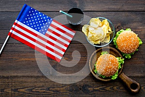 Flag usa and national food, burgers, chips and drink on wooden background top view