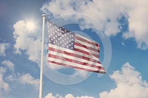 Flag of USA, National symbol waving against cloudy, blue sky, sunny day