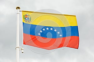 Flag of Venezuela against white cloudy sky