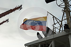 Flag of Venezuela flies on the wind and hanging on the navigational mast.