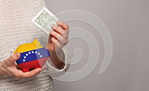 Flag of Venezuela on money bank in Venezuelan woman hands. Dotations, pension fund, poverty, wealth, retirement concept