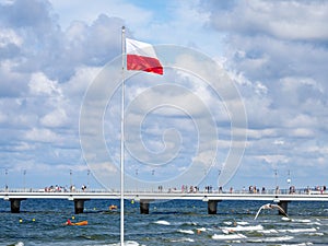 On flagpole the red and white flag of Poland is waving