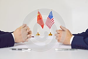 Flags of America and China atand on table during talks between diplomats and businessmen.