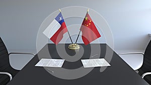 Flags of Chile and China and papers on the table. Negotiations and signing an international agreement. Conceptual 3D