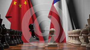 Flags of China and Chile behind pawns on the chessboard. Chess game or political rivalry related 3D rendering