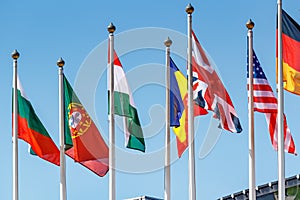Flags of different countries on the flagpoles in sunlight