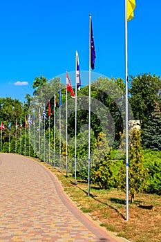 Flags of different countries on high flagpoles in park