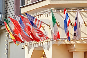 Flags of different countries in holders on building wall