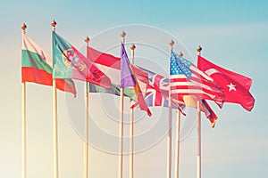 Flags of different countries on the white flagpoles