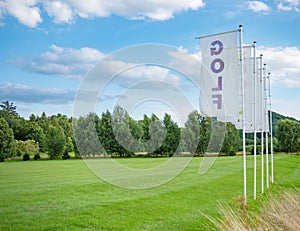 Flags at driving range for practicing golf swing. Nice landscape in sunny day