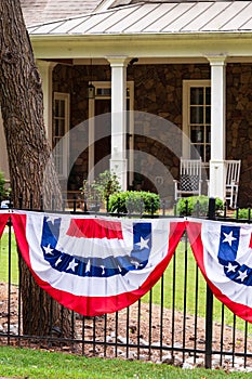 Flags flying on the fence by the front porch of the house