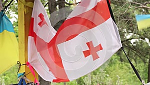 Flags of Georgia and Ukraine hang at a bus stop near a bombed house in the Dnieper, solidarity and