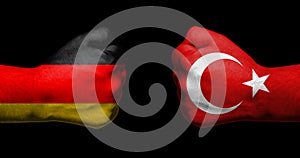 Flags of Germany and Turkey painted on two clenched fists facing