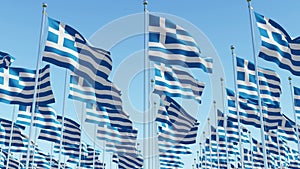 Flags of Greece waving against clear blue sky.