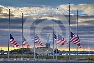 Flags at half staff in front of Statue of Liberty