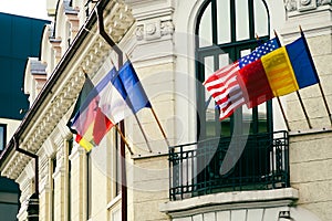 Flags hoisted on the facade of a building. photo during the day.