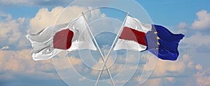 flags of Japan and The European Union and flag of Belarus waving in the wind on flagpoles against sky with clouds on sunny day.