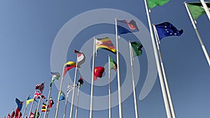 Flags of many Nations against a blue sky - national flags of various countries waving in the wind