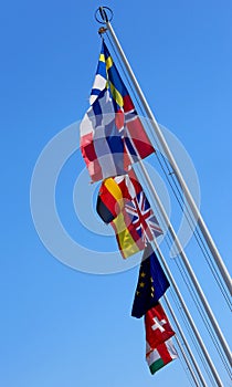 Flags of many nations world waving in the blue sky