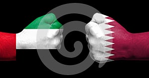 Flags of Qatar and Saudi Arabia painted on two clenched fists fa