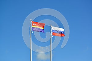 Flags of Russia and the Kaliningrad region, fluttering against the blue sky