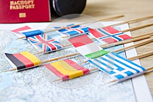 Flags on travel map, camera, passport close-up. travel destination planning concept