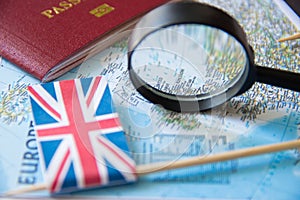 Flags of UK, magnifying glass, passport on a map. Tourism concept