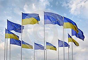 Flags of Ukraine and European Union EU against the blue sky.