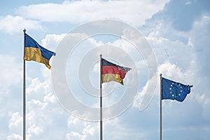 Flags of Ukraine, Germany and the European Union flutter on wind