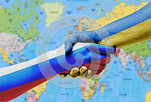 The flags of Ukraine and Russia shake hands on the background of the world map.