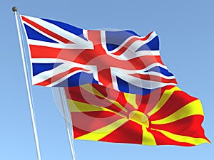 The flags of United Kingdom and Macedonia on the blue sky. For news, reportage, business. 3d illustration