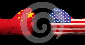 Flags of USA and China on two clenched fists facing each other on black background/usa china trade war concept