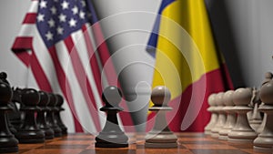 Flags of the USA and Romania behind pawns on the chessboard. Chess game or political rivalry related 3D rendering