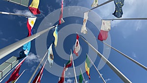 Flags of the World waving in the wind on a background blue sky and white clouds.