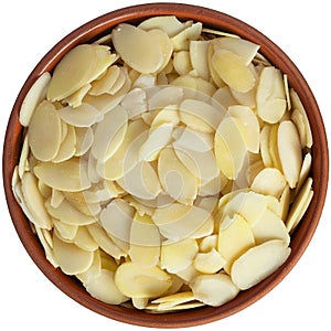 Flaked almonds in a brown ceramic bowl. Isolated close-up photo of food close up from above on white background